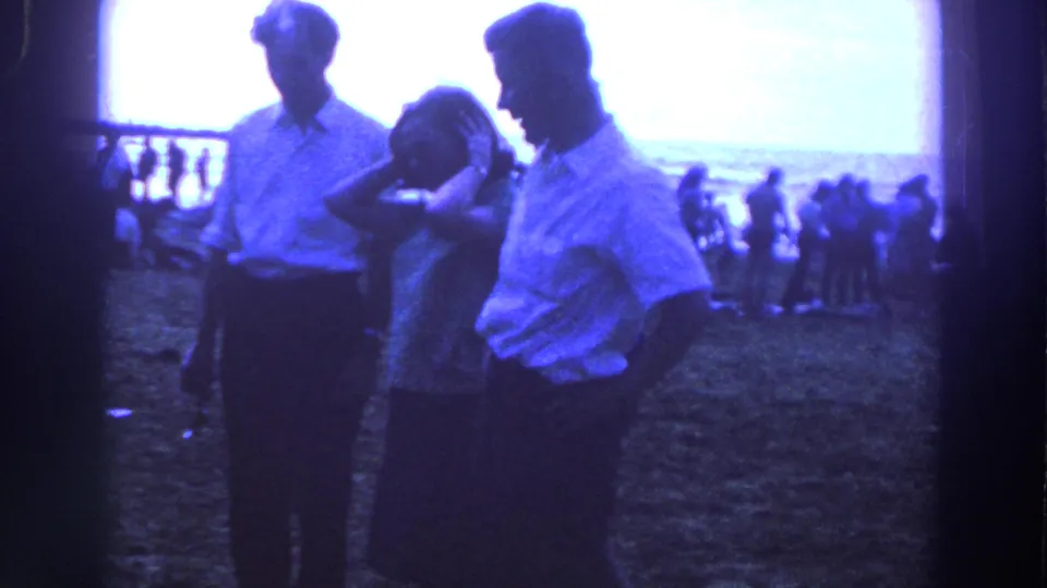 The final frame shows the same three adults in 1961 Ireland, backlit on grass with distant figures and a railing behind them.