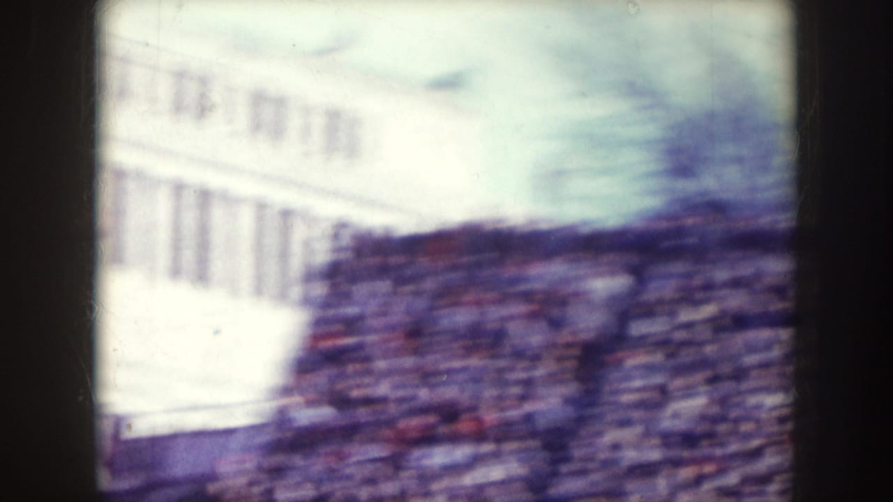 Blurred stadium building and crowded stands seen during a handheld pan.