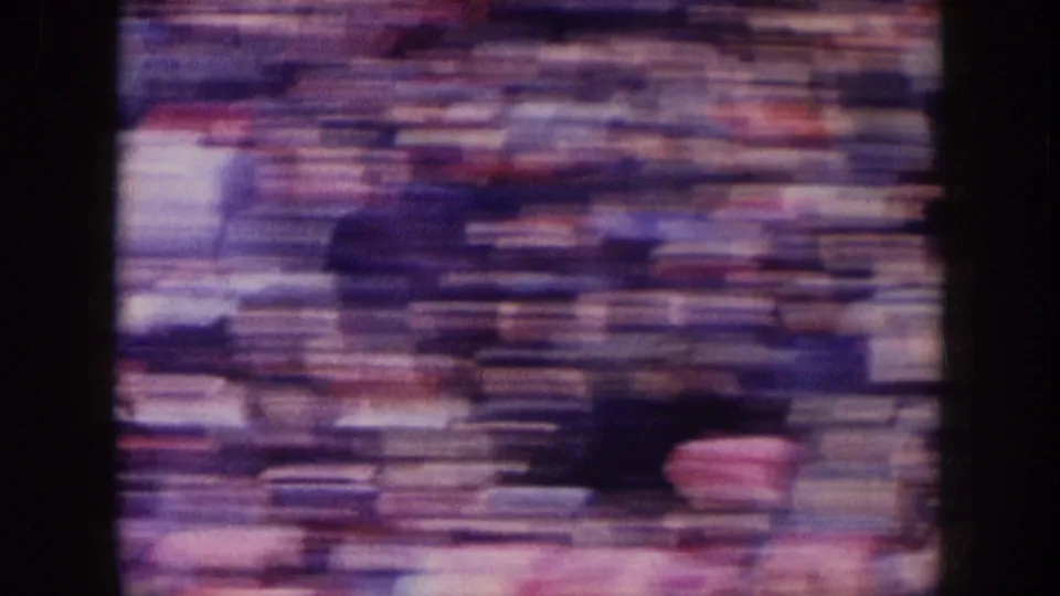 1957 Nebraska football crowd rendered in heavy motion blur as the handheld camera sweeps across the stands.