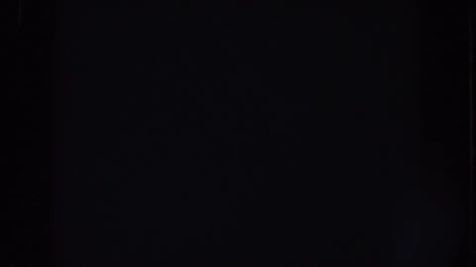 Dark 8mm home-movie frame with minimal visible detail, likely from a transition or underexposed end frame.