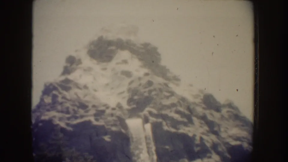 1962 Disneyland home-movie frame showing the Matterhorn attraction peak in soft focus with visible film grain.