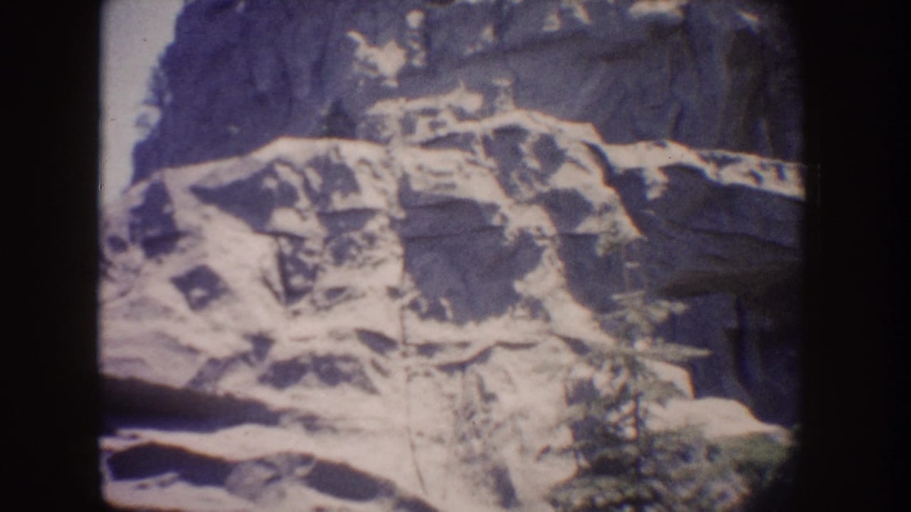 Dim rectangular view of pale rocky landscape surrounded by dark ride interior.
