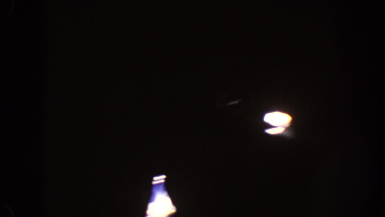 Mostly black frame with faint bright highlights near the upper area.