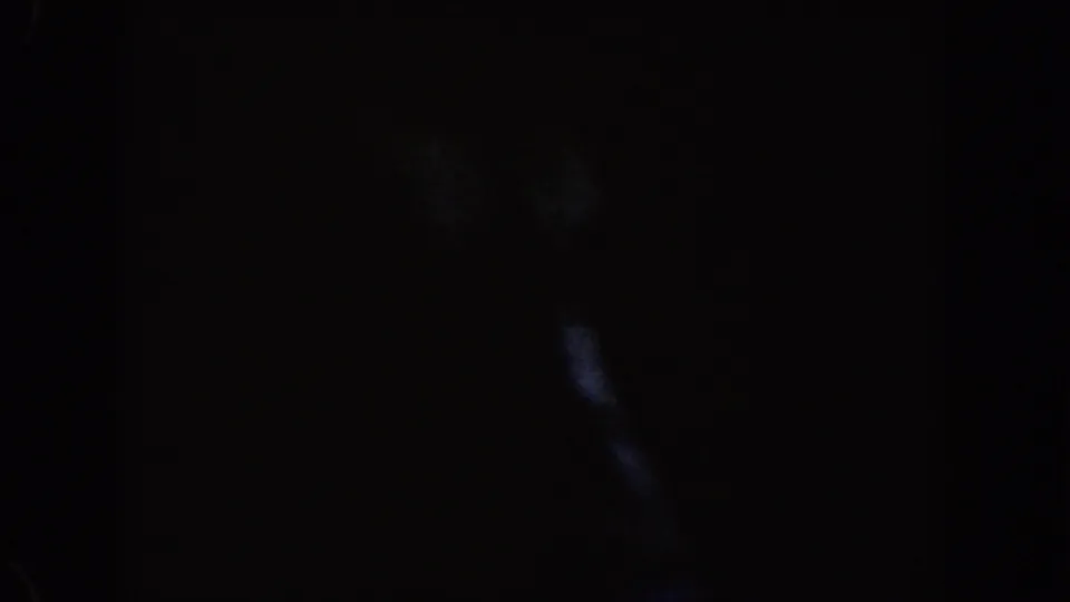 Dark end frame from the Disneyland train ride footage, showing faint reflections or interior edges in heavy shadow.