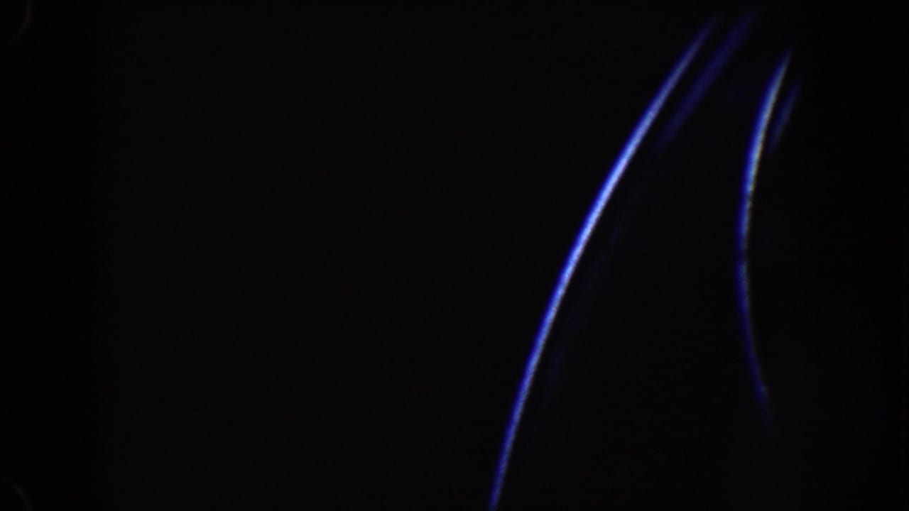 Mostly black frame with curved blue light streaks at the right edge.