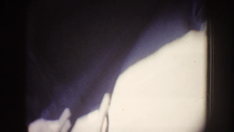 Overexposed 1962 Disneyland ride frame with a bright opening, dark vertical edge, and blurred shapes from the moving camera.