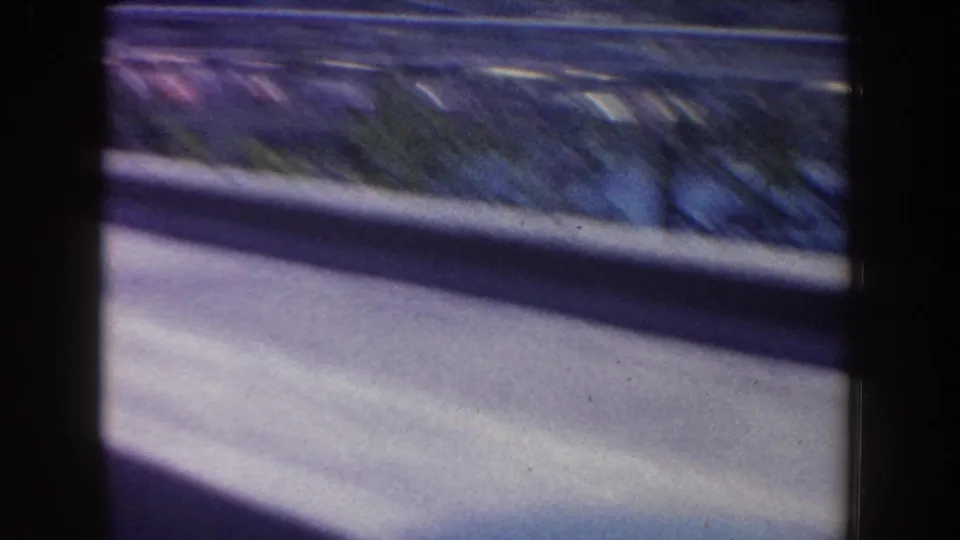 Curving ride roadway and low barrier at Disneyland, filmed from a moving car in 1962.