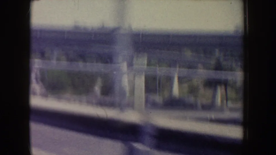 Soft 8mm view at Disneyland in 1962 showing a station-like structure or platform glimpsed from a moving vehicle window.