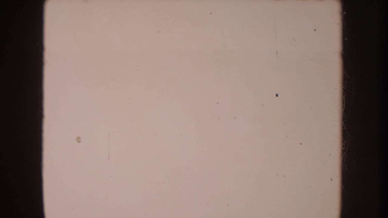 Mostly pale exposed film frame with dust, scratches, and dark vertical frame edges.