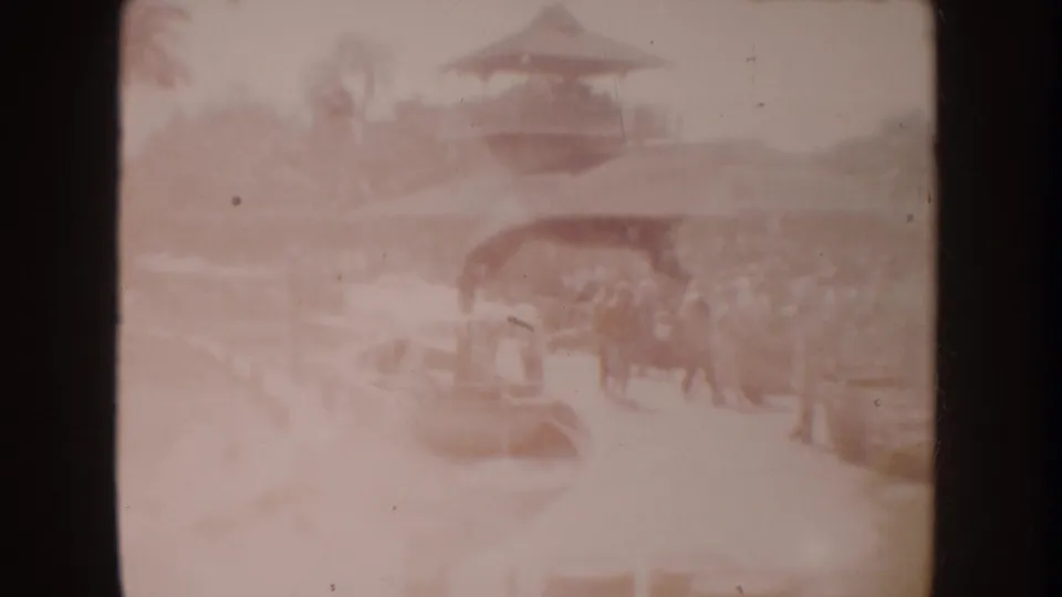 1962 Disneyland frame showing a pagoda-style roof, canal edge, small boat area, and distant park visitors.