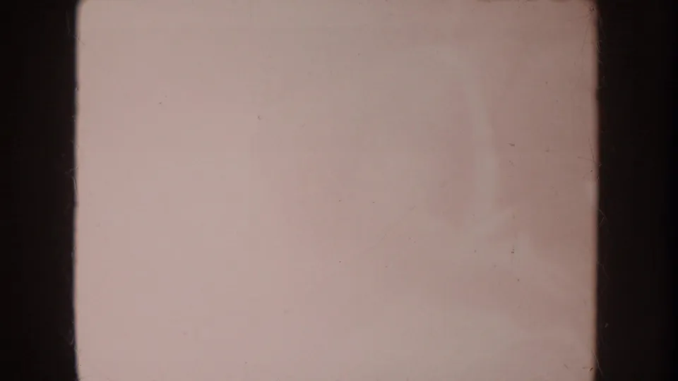 Soft, overexposed 1962 Disneyland 8mm frame with dark vertical gate edges and indistinct pale shapes.