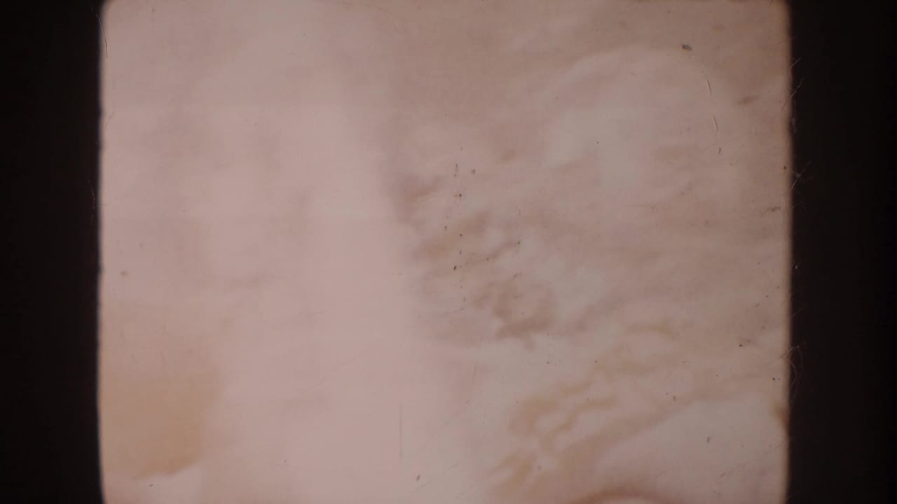 Soft, overexposed frame with a small child shape partly visible near pale ground.