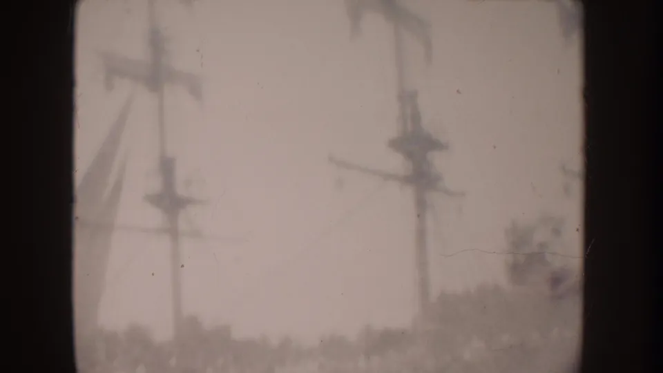 1962 Disneyland-area frame with electric poles and wires silhouetted against a pale, hazy sky.