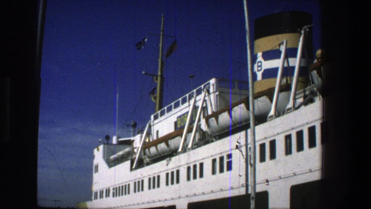 White passenger ferry at port with striped funnel and mast against a blue sky.