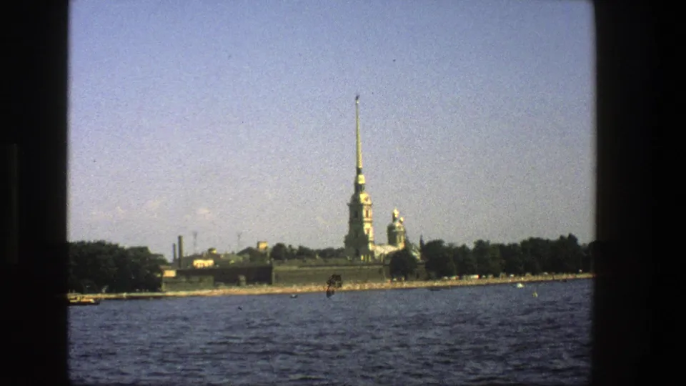 Metadata-listed Denmark travel footage shows a tall green-roofed spire and low waterfront buildings across blue water.