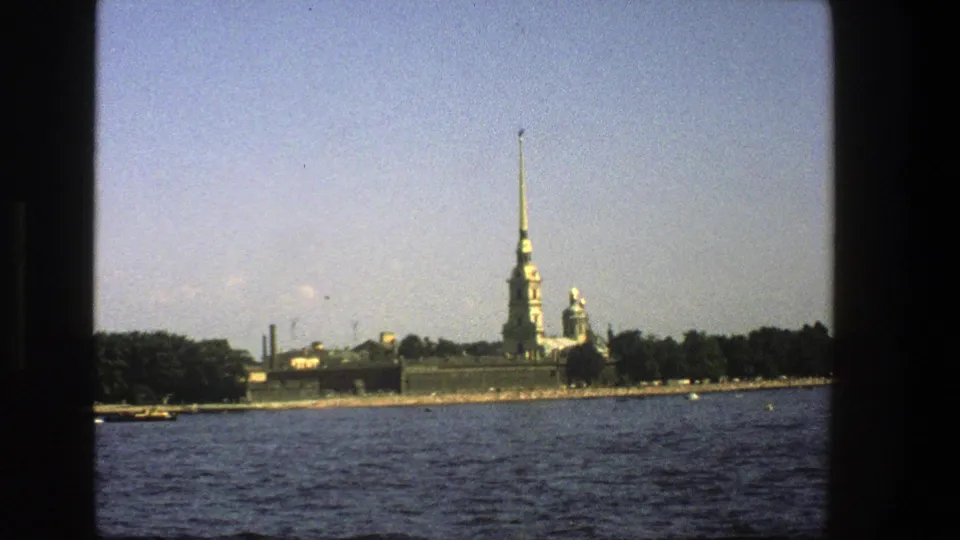 Final 8mm frame shows the spired shoreline across blue water, still bordered by dark boat-window edges.