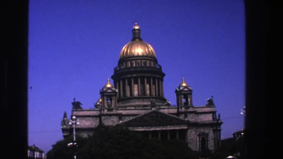 1975 color 8mm frame showing the same domed landmark exterior, with warm highlights on the dome and dark window-like borders.