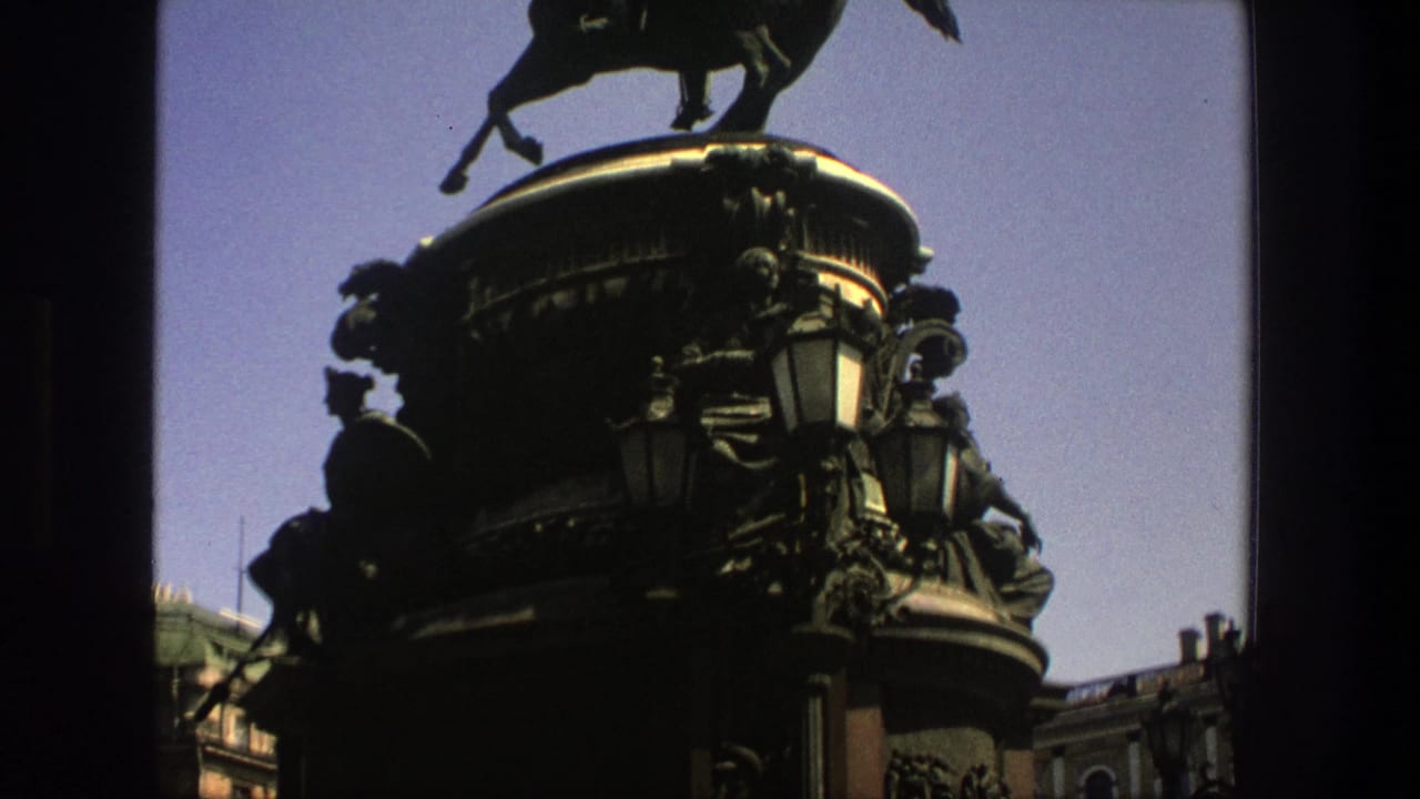 1975 8mm Denmark-labeled footage shows an ornate equestrian monument with a dark sculpted pedestal and street lamps.