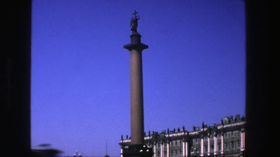 The final frame holds on the monument column and statue, with palace architecture low in the frame.