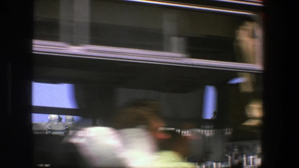 The final Denmark bus-view frame shows a blurred passerby, dark window framing, and an ornate building roofline behind the moving vehicle.