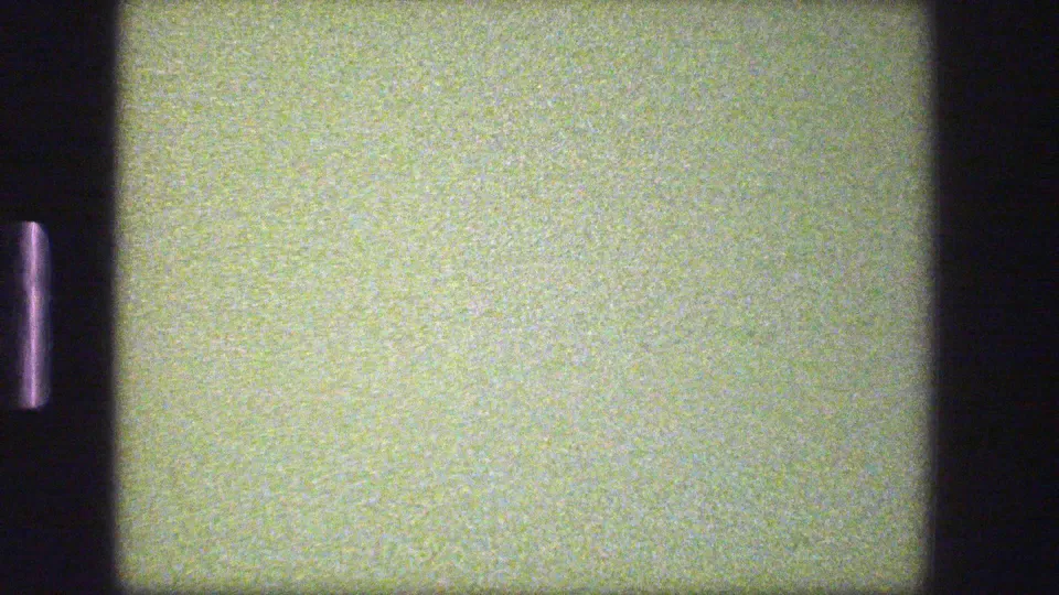 A grainy 1975 tram-window frame in Denmark shows a close pale construction surface and dark window framing with little exterior detail.