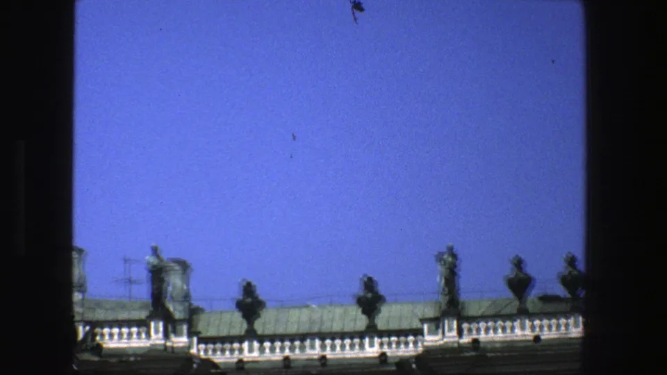 Soft 8mm view of Danish rooftop ornament, with small statues and urns along a bright balustrade under open sky.