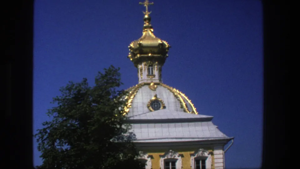 1975 Denmark 8mm frame showing the ornate church dome slightly lower in frame, with roofline, windows, and dark foliage.