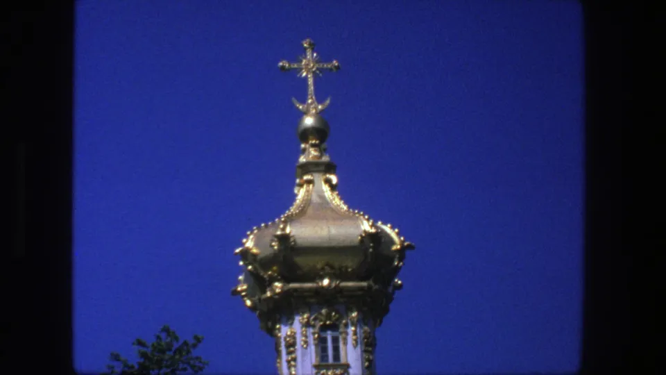 1975 Denmark 8mm frame showing an ornate gold church dome topped by a cross against a saturated blue sky.