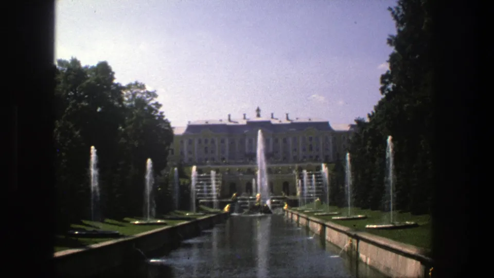 Visitor-shot 8mm view in Denmark, 1975, looking down a formal water garden toward a palace-like facade.