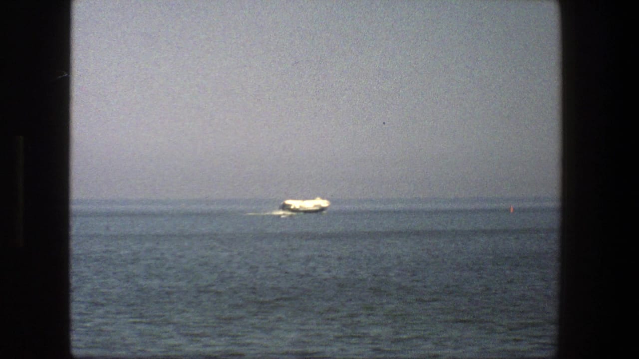 White boat farther right on open water with a faint wake.