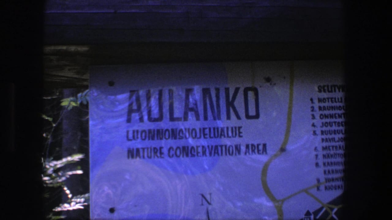 Close 8mm view of the Aulanko Nature Conservation Area sign, with a route map and numbered visitor list partly visible.