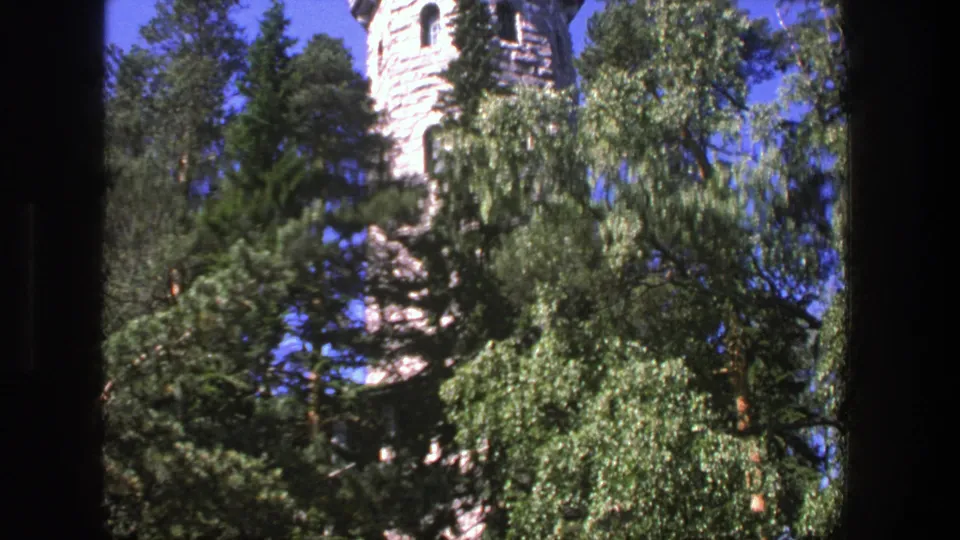 1975 Denmark 8mm frame showing the tower lower in the frame as dense trees and foliage obscure much of the structure.