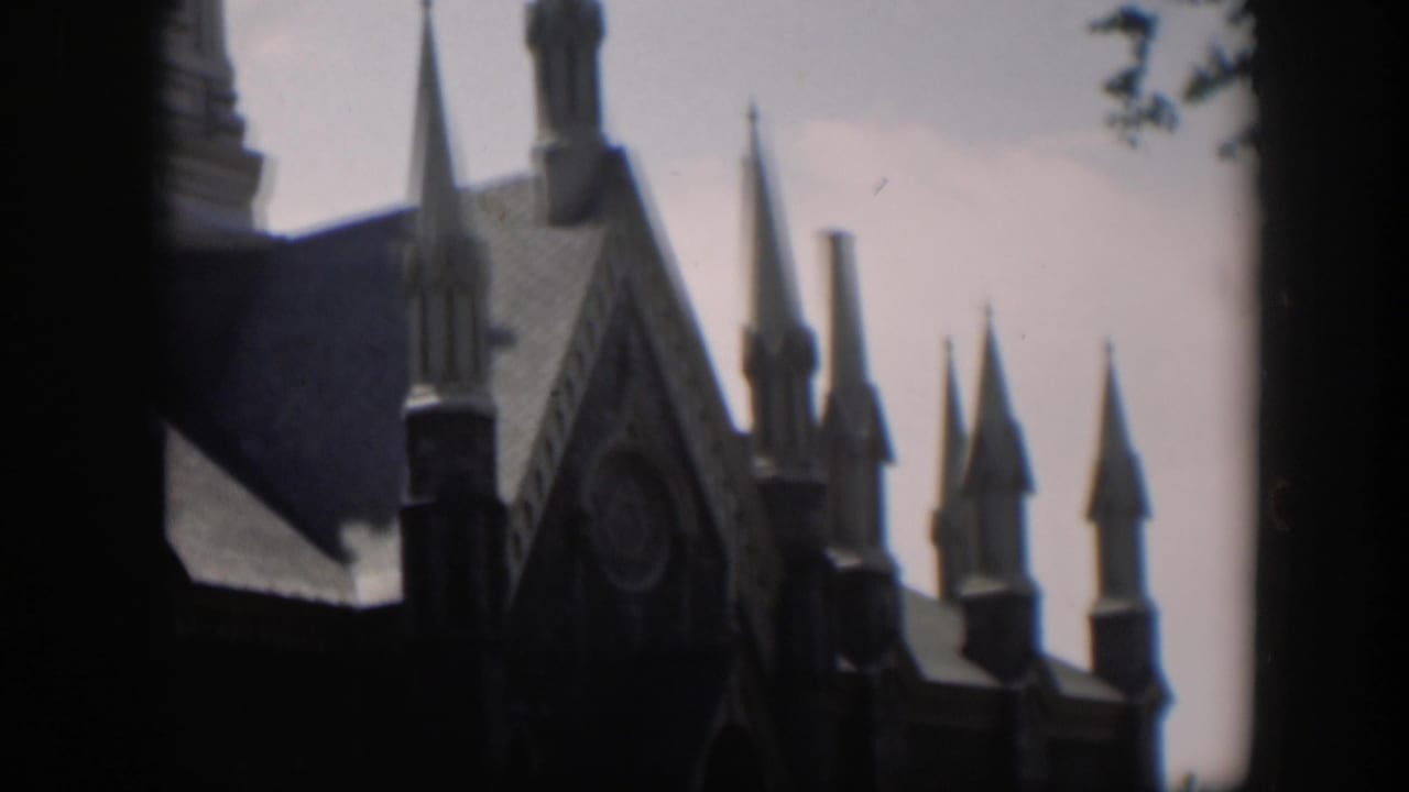 Cluster of pointed church spires and a Gothic facade partly framed by dark edges.