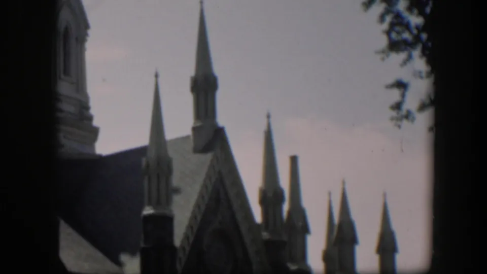 1951 Wyoming 8mm view of a Gothic-style church exterior with tall spires, roofline details, and a muted sky.