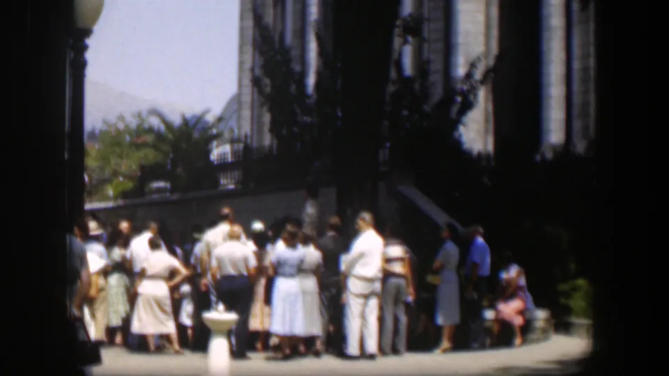 A larger view of the 1951 Wyoming gathering shows adults facing inward near the building entrance and white pedestal.