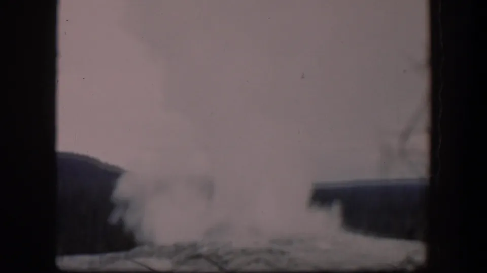 1951 Wyoming 8mm frame showing a pale steam plume from a geothermal vent, partly obscured by film gate bars and soft focus.
