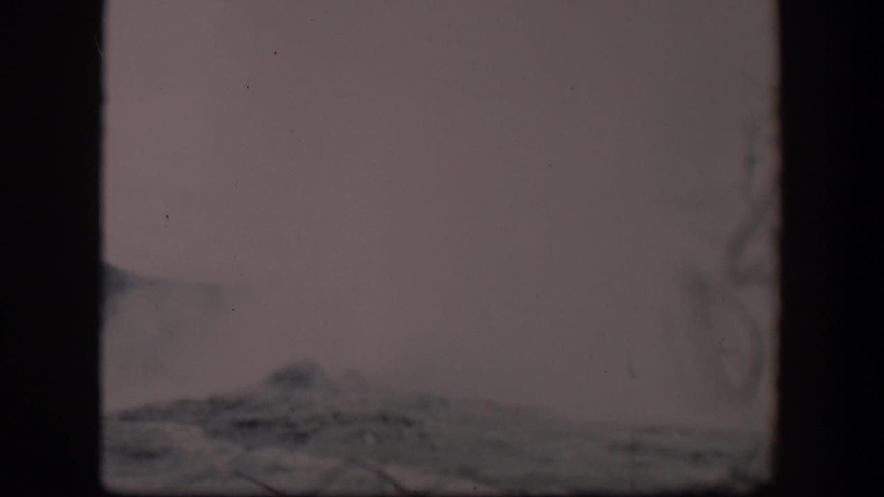 Low steam and rocky terrain seen through soft 8mm film texture.