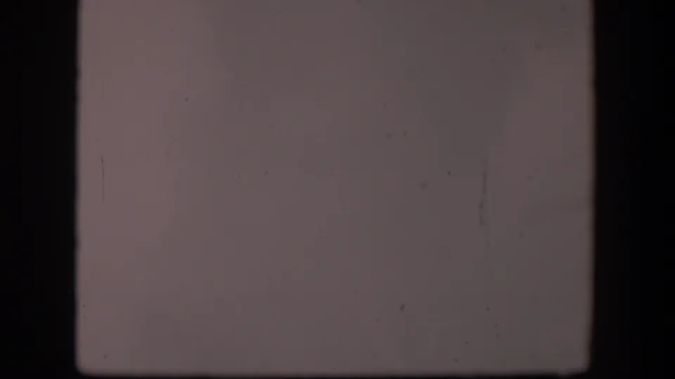1951 Wyoming 8mm frame showing mostly pale sky inside dark film or window framing, with faint marks and little detail.