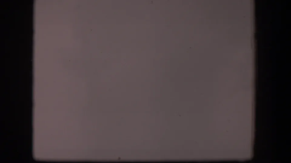 1951 Wyoming 8mm frame showing a washed, nearly featureless view with dark gate borders and visible surface marks from the film scan.
