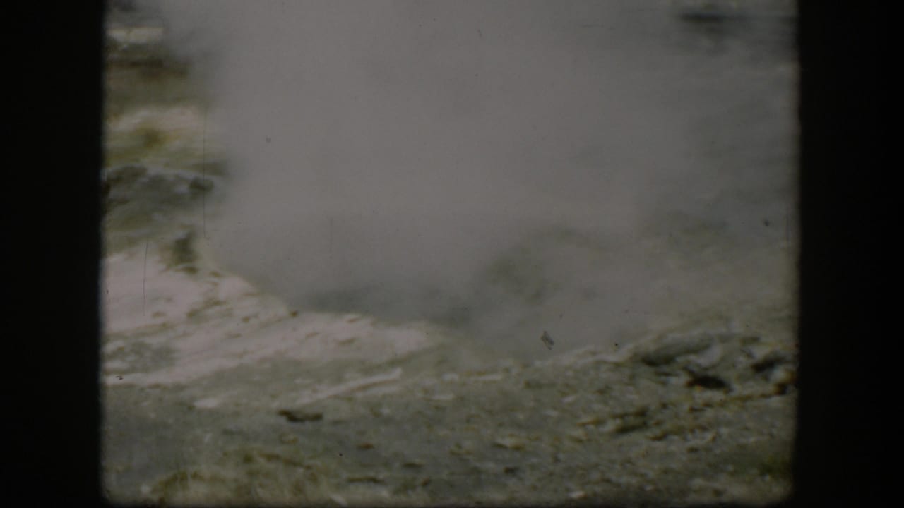1951 Wyoming 8mm frame showing steam or vapor rising from pale ground, consistent with a geothermal feature.