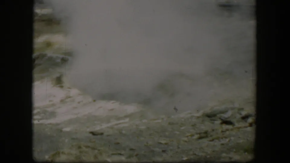 1951 Wyoming 8mm frame showing steam or vapor rising from pale ground, consistent with a geothermal feature.