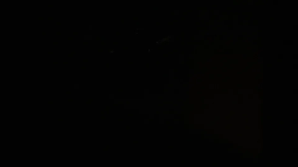 Very dark 1951 Wyoming home-movie frame with faint framing edges and minimal visible landscape detail.
