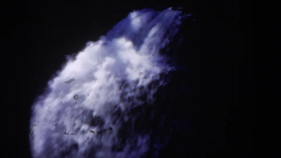1951 Wyoming 8mm frame with white foaming water cascading over a dark rocky edge, rendered in high-contrast blue-purple vintage color.