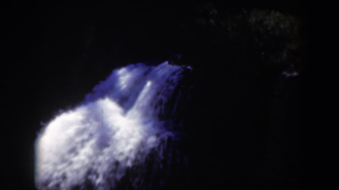 1951 Wyoming 8mm frame with the waterfall centered against a dark wooded backdrop and little surrounding detail.