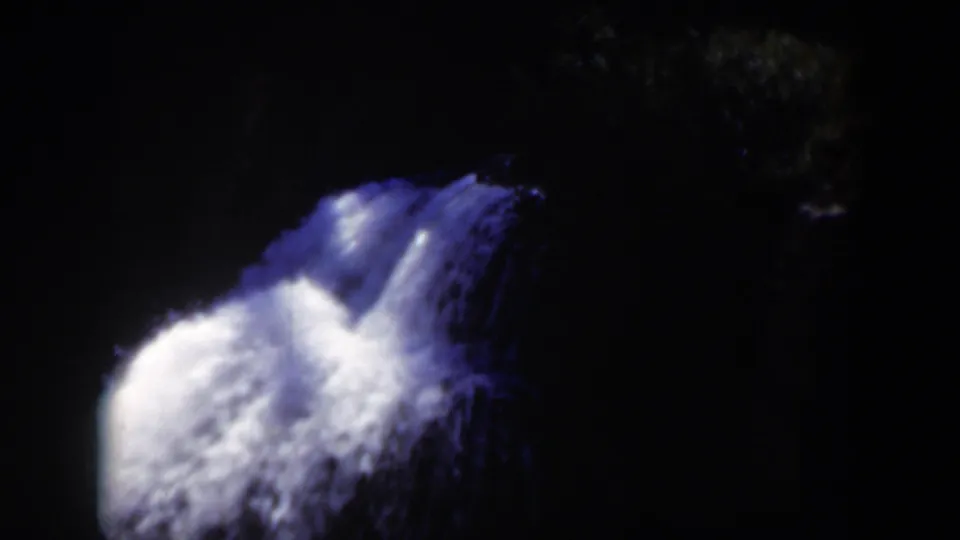1951 Wyoming 8mm frame with the waterfall centered against a dark wooded backdrop and little surrounding detail.