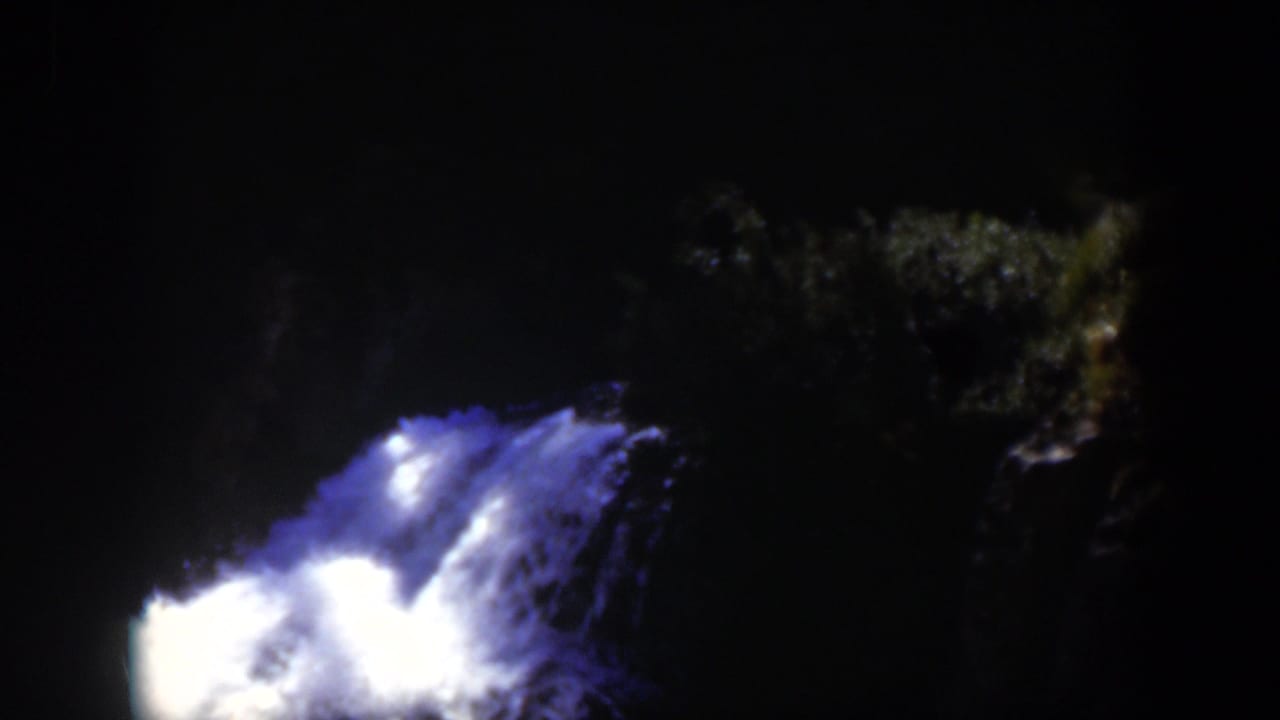 1951 Wyoming-associated 8mm frame with turbulent blue-white water lit against a black nighttime background.