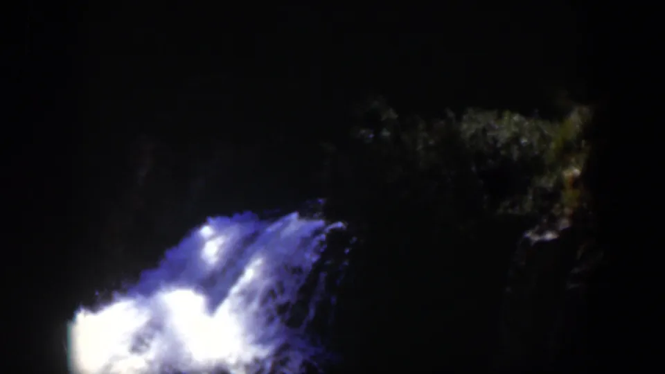 1951 Wyoming-associated 8mm frame with turbulent blue-white water lit against a black nighttime background.