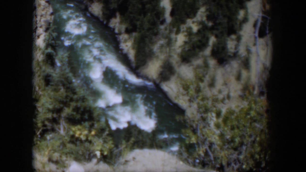 1951 Wyoming 8mm view of a turbulent green-blue river running through a tree-lined canyon.
