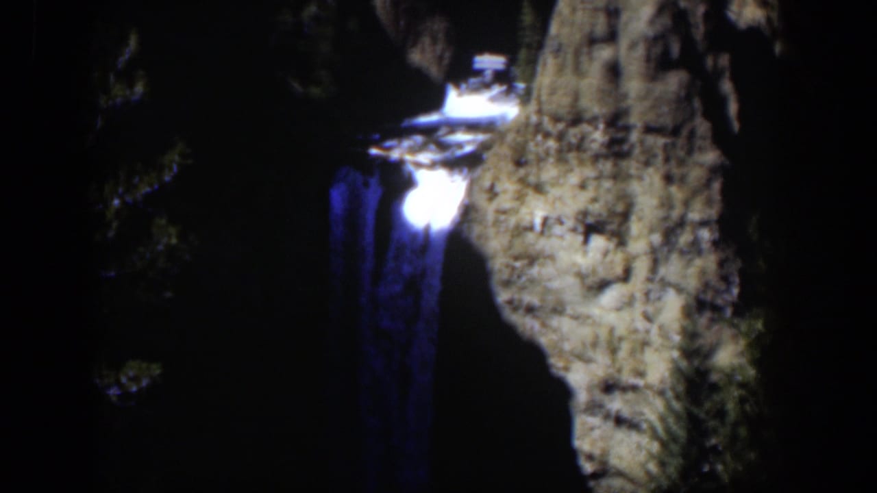 Final frame holds on the glowing waterfall and textured canyon rocks, with surrounding trees mostly in shadow.