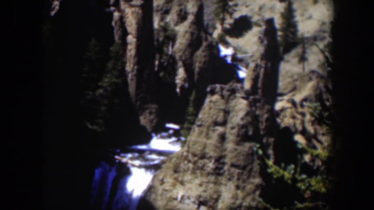 1951 Wyoming 8mm still showing bright falling water framed by rough canyon rock and dark trees.